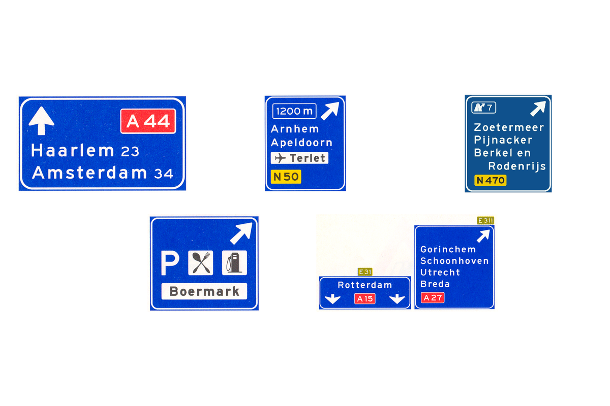 Wegwijzers langs de autosnelweg: doorgaande richting, twee afritten met afstand en met afritnummer, een verzorgingsplaats en een splitsing