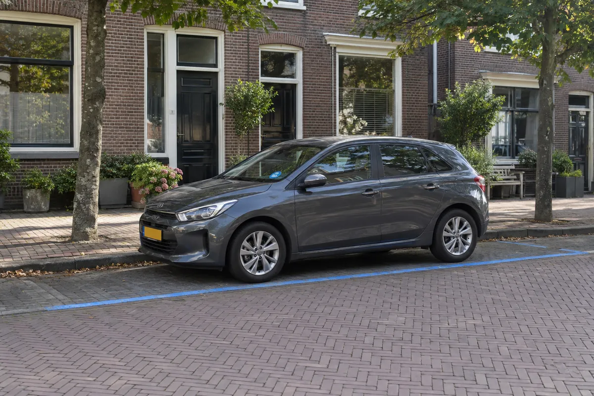 Een auto op een parkeerplaats langs de weg, met een blauwe streep langs de rand van het parkeervak