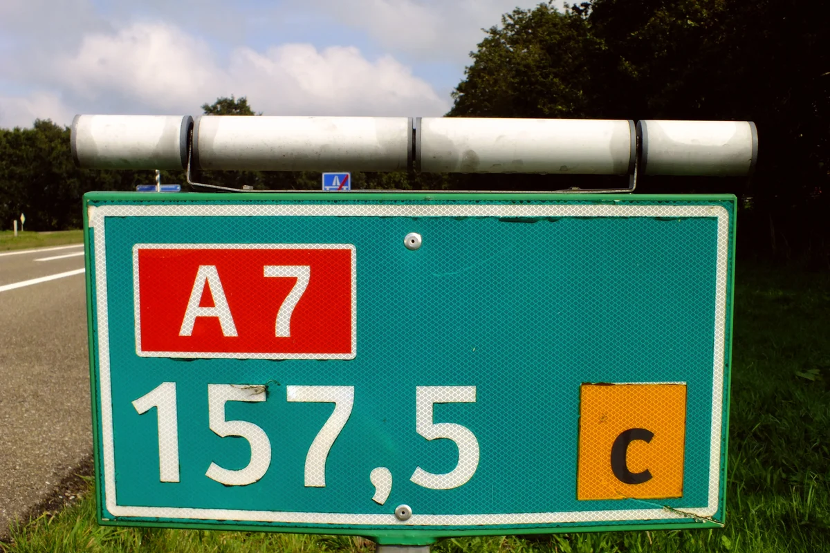 Hectometerbordje langs de A7 met het wegnummer A7, de hectometeraanduiding 157,5 en de letter c