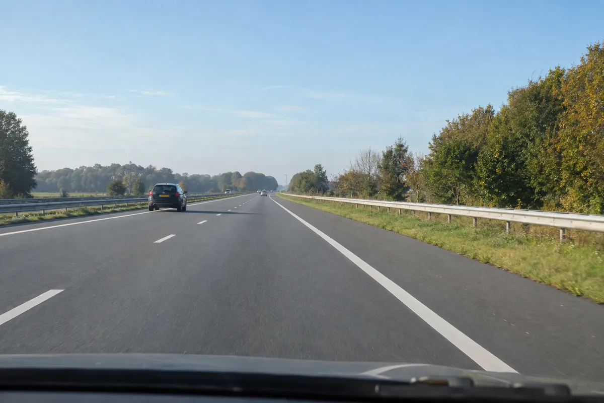 Je krijgt pech op de snelweg. Rechts liggen de vluchtstrook, berm en vangrail; je hebt nog geen stopplek gekozen.