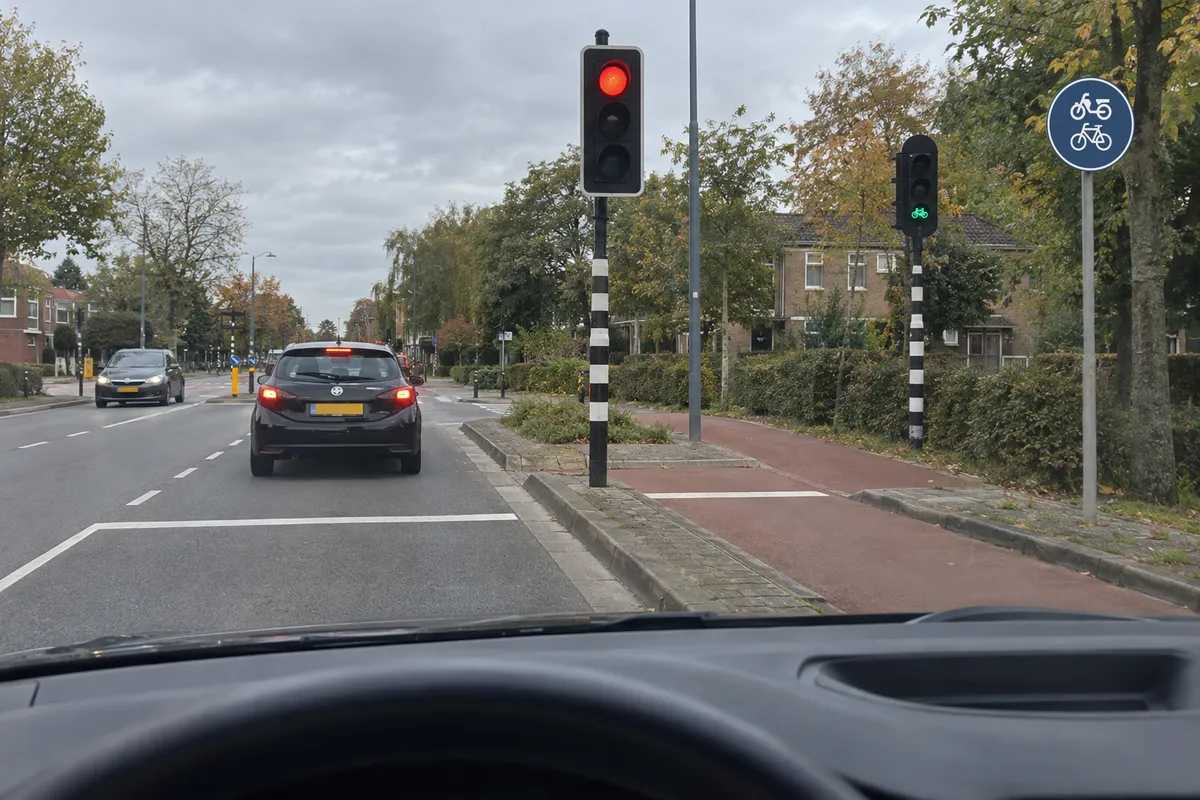 Naast het rode licht voor de rijbaan toont het aparte fietslicht op het fiets-/bromfietspad een groene fiets.