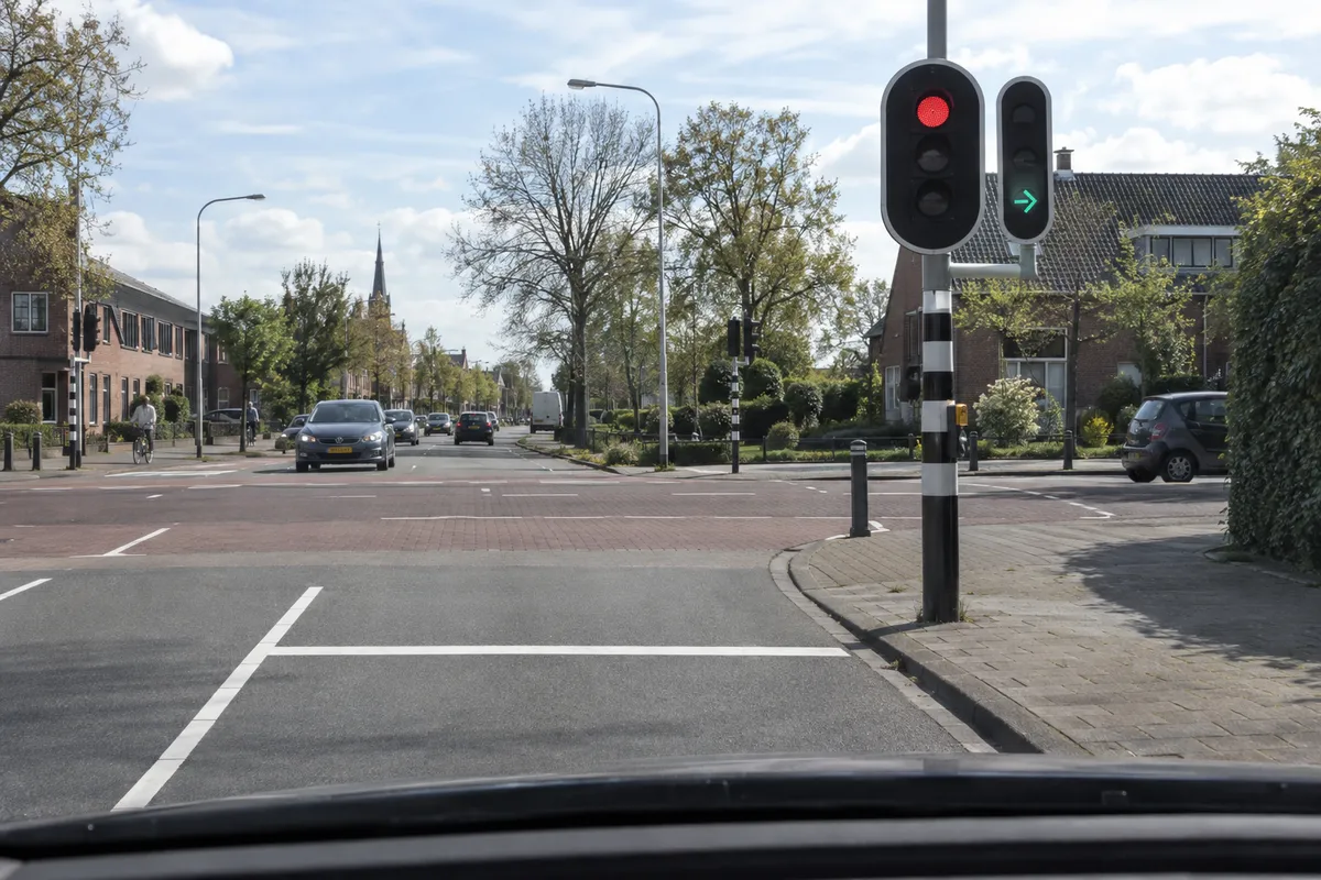 Naast het rode verkeerslicht brandt in een apart apparaat een groene pijl naar rechts.