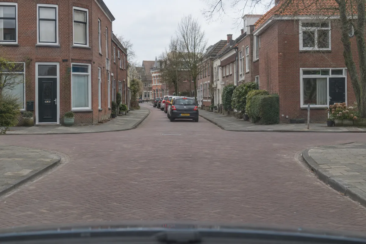 Zicht vanuit de auto op een kruispunt: aan de overkant staat een rij auto’s stil zonder ruimte voor de eigen auto